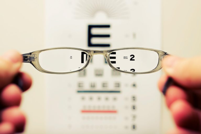 Glasses in front of a eye chart.